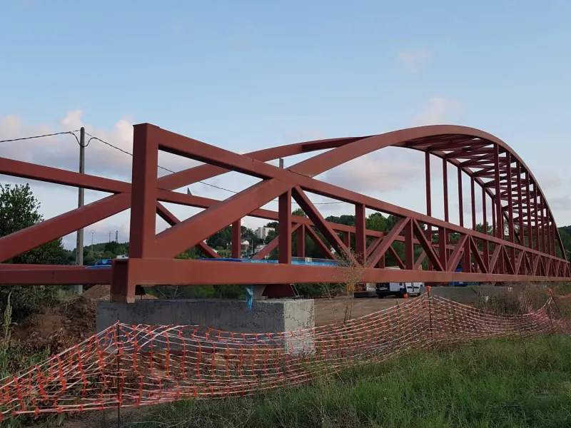 Pasarela metálica en la localidad de Masquefa.Con una longitud total de 72 metros y 3 metros de ancho, atirantada a arco con secciones tubulares, para el izado se precisaron de dos grúas móviles de gran tonelaje.